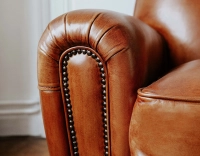 Sillón club de piel marrón claro reposabrazos con tachuelas