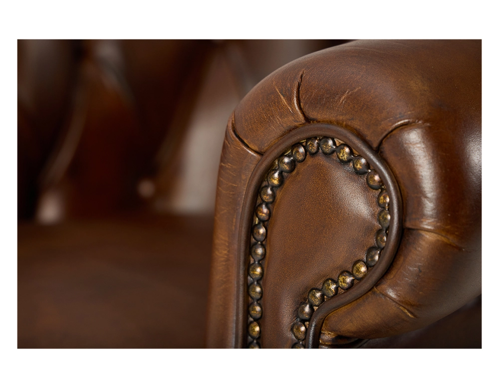 Fauteuil chesterfield cuir marron vintage accoudoirs cloutés
