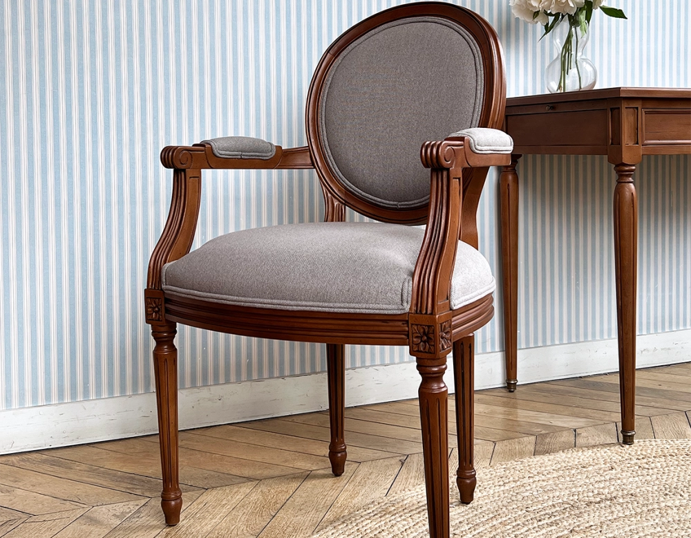 Antique Louis XVI style armchair with armrests wood stained in an antique style and light grey fabric