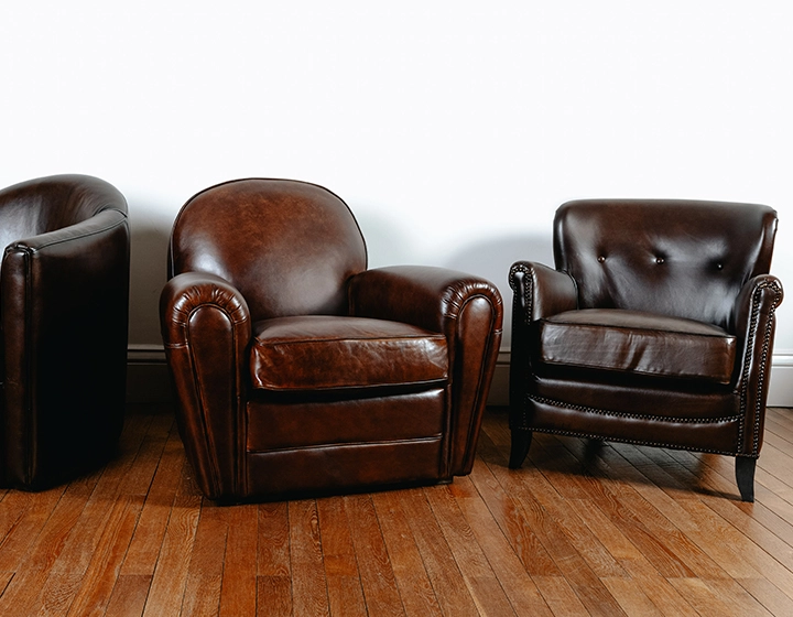 Fauteuil club cuir marron soutenu accoudoirs cloutés