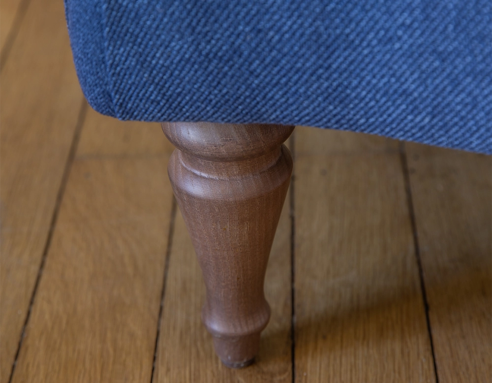 Fauteuil crapaud avec accoudoirs pieds bois teinte noyer et tissu bleu marine haut dossier