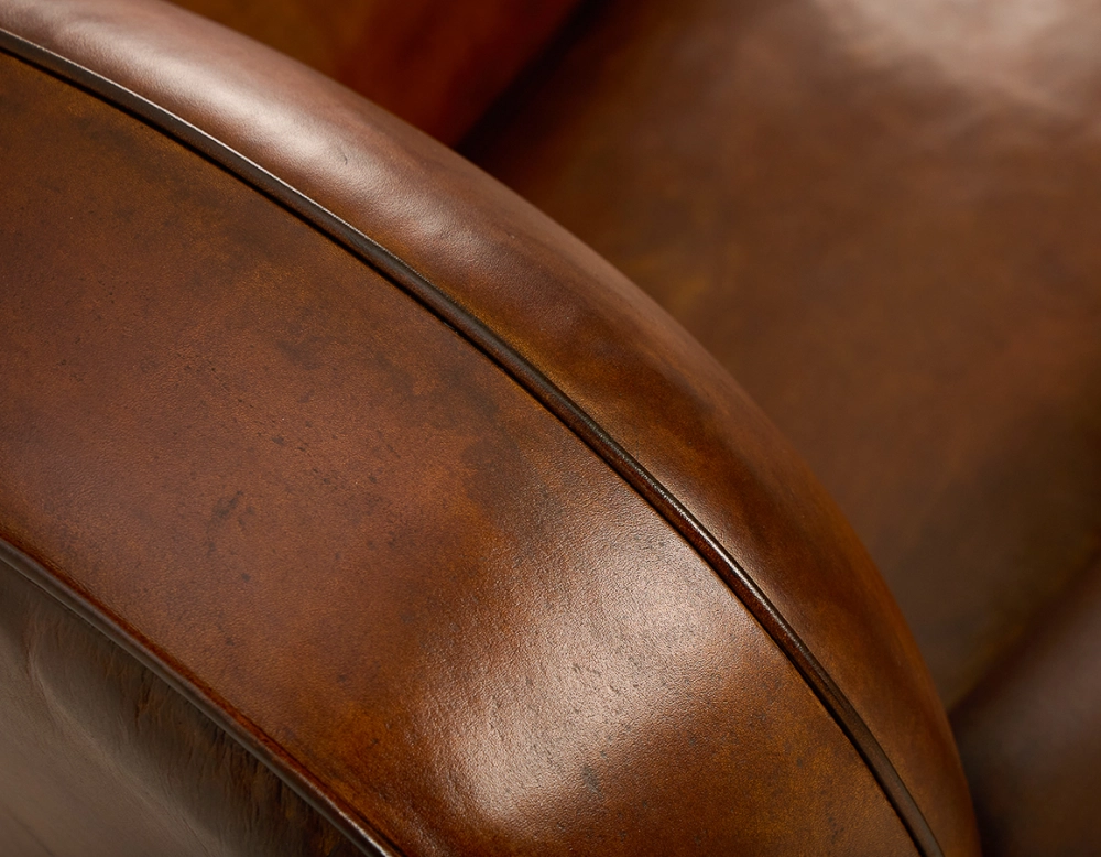 Fauteuil club cuir marron vintage accoudoirs cloutés