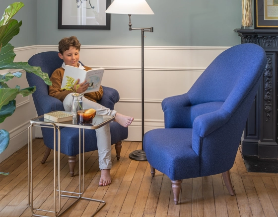 Fauteuil crapaud avec accoudoirs pieds bois teinte noyer et tissu bleu marine haut dossier